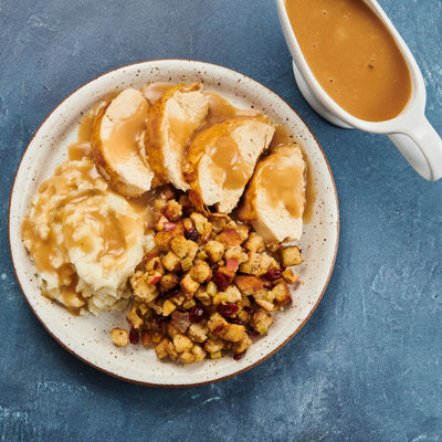 A plate of roast turkey, mashed potatoes and gravy